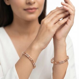 A pair of 18k gold minimalist double-band bangles with stone accents by OVJ Jewels.