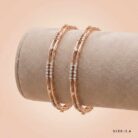 A pair of 18k gold minimalist double-band bangles with stone accents by OVJ Jewels.