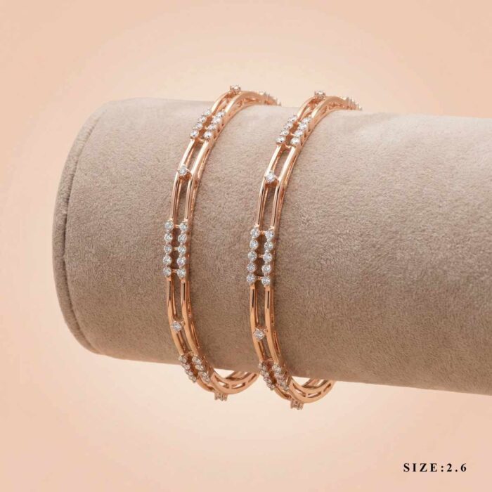A pair of 18k gold minimalist double-band bangles with stone accents by OVJ Jewels.