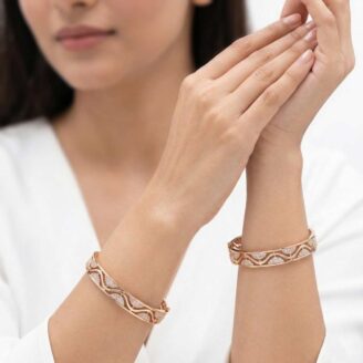 "Pair of 18k gold minimalist bangles featuring a wave cut-out design with small stones, size 2.5, by OVJ Jewels."