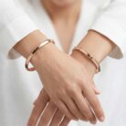 Two 18k rose gold minimalist bangles with flush-set stones and geometric inner detailing, size 2.6, by OVJ Jewels.