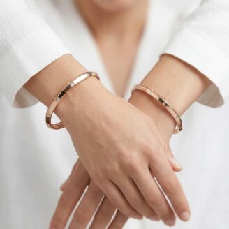 Two 18k rose gold minimalist bangles with flush-set stones and geometric inner detailing, size 2.6, by OVJ Jewels.