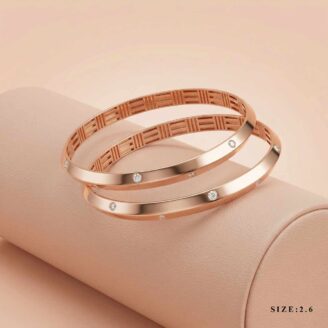 Two 18k rose gold minimalist bangles with flush-set stones and geometric inner detailing, size 2.6, by OVJ Jewels.